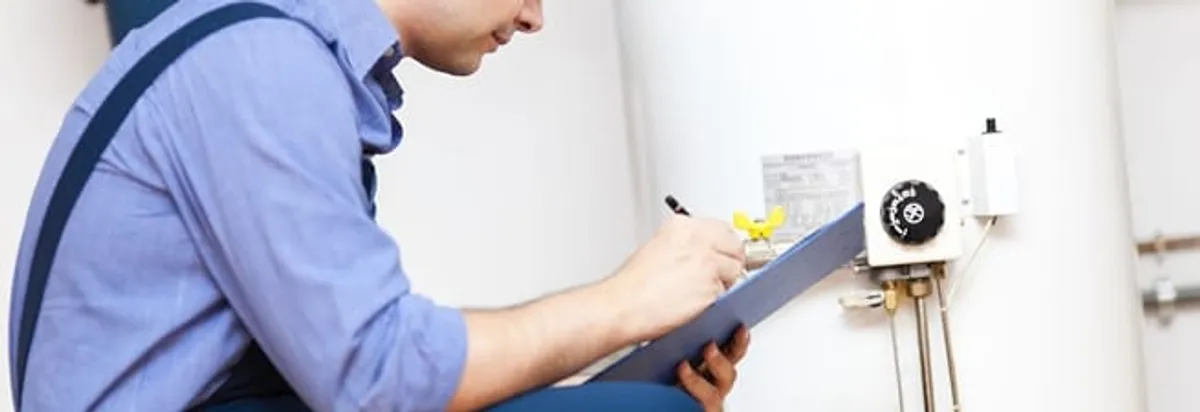 Water heater repair technician inspecting the unit and recording service notes in Pittsburgh, PA